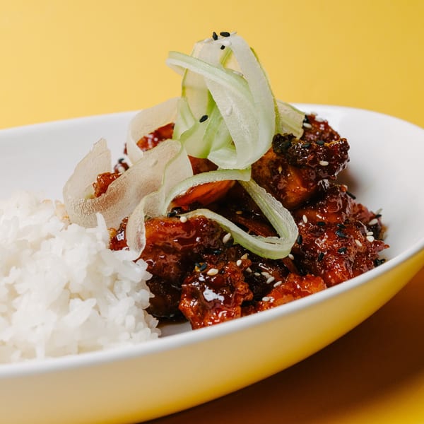 Noods To Go's Asian-fusion dish with sticky glazed chicken, white rice, and cucumber ribbons.